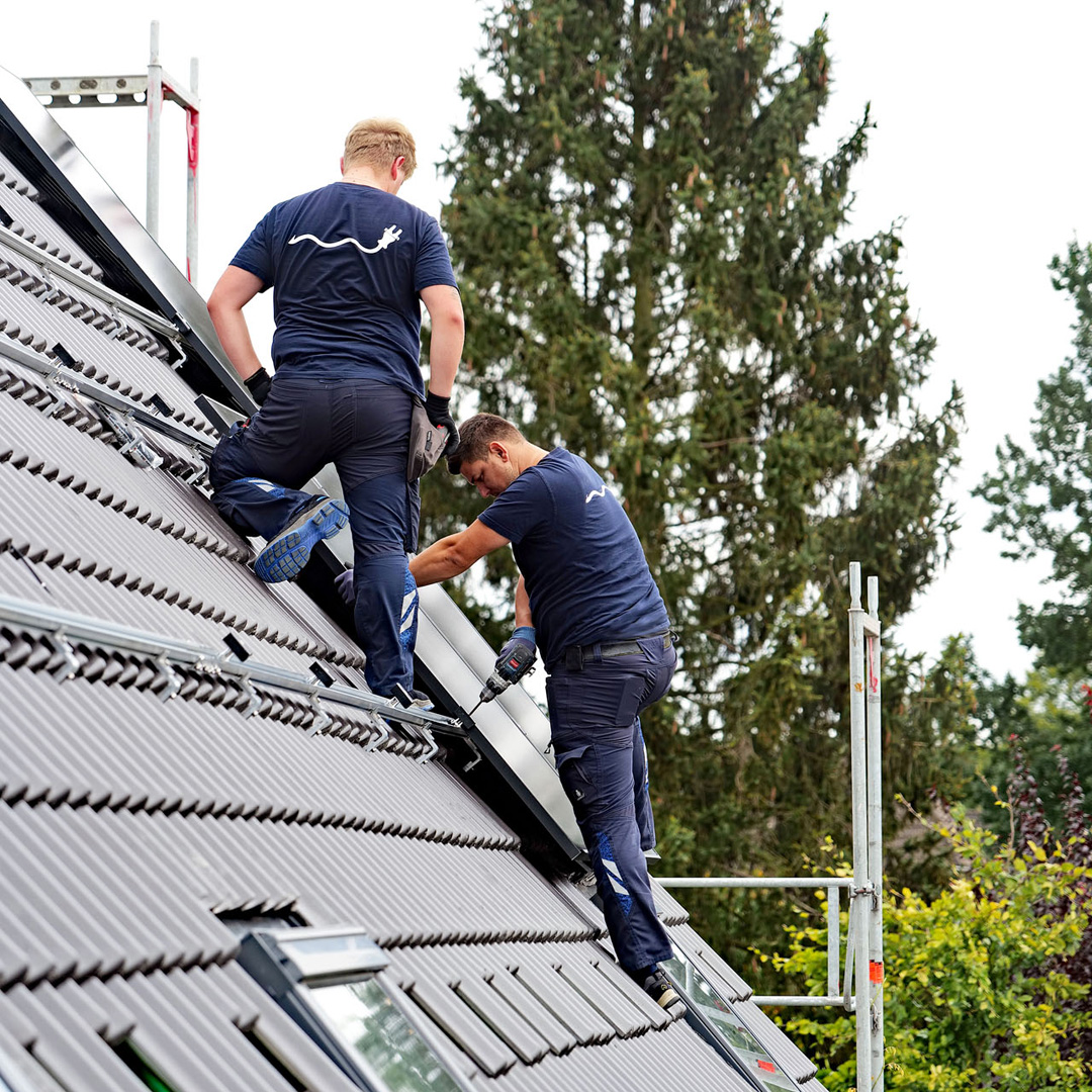 Aufbau einer Photovoltaik-Anlage auf einem Dach durch zwei Fachleute von Elektromeister Gerckens, Dobberstein